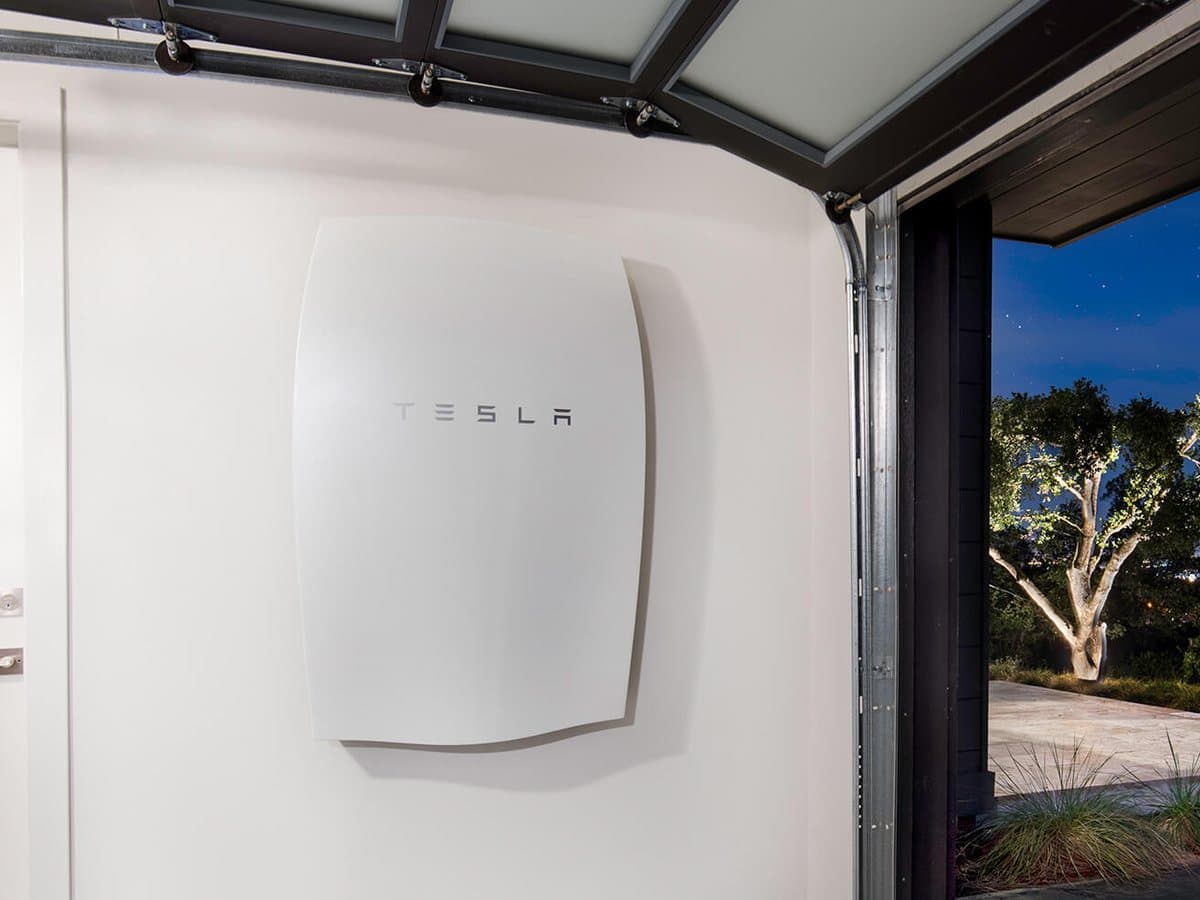 Tesla Powerwall installed on a garage wall at night